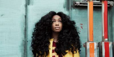 SZA press shot blue wall