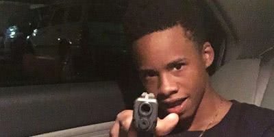 Photo of rapper Tay-K holding a gun