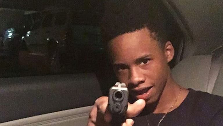 Photo of rapper Tay-K holding a gun