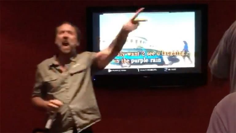 Image of Nicolas Cage performing Prince's 'Purple Rain' at a karaoke bar