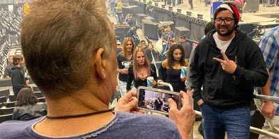 Image of Eddie Van Halen taking a photo of a fan at a Tool concert