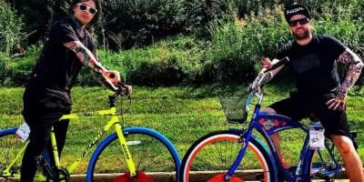 Falling In Reverse members Ronnie Radke and Derek Jones posing with bicycles.