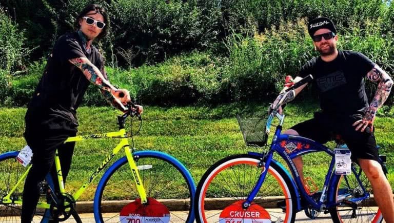 Falling In Reverse members Ronnie Radke and Derek Jones posing with bicycles.