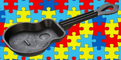 Cast iron guitar skillet in front of an autism puzzle background.