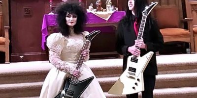 The couple with their Gibson guitars at their wedding