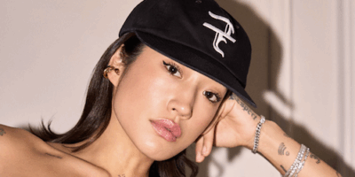 Peggy gou in a hat posing for the camera, leaning on her arm