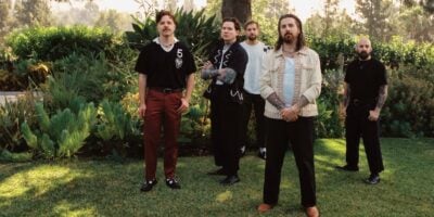 The Devil Wears Prada standing in a field surrounded by trees