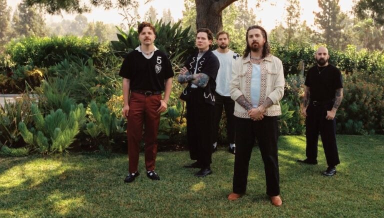 The Devil Wears Prada standing in a field surrounded by trees