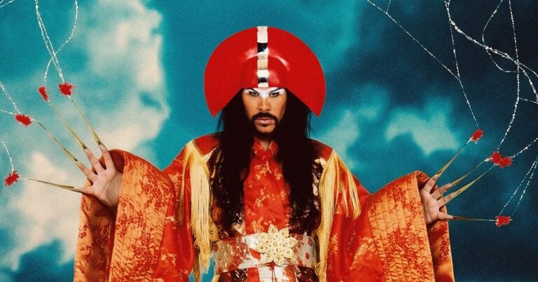 Luke Steele of Empire of the Sun wearing an ornate red and gold costume against a blue background